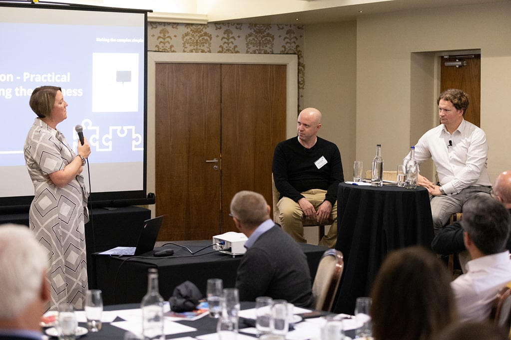 A small seminar setup with a speaker addressing seated attendees.